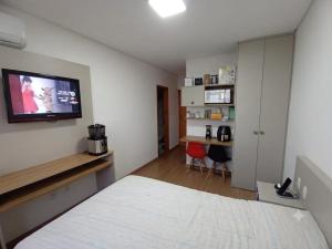 a bedroom with a bed and a tv on the wall at Edifício Paris 411 in Lagoa Santa