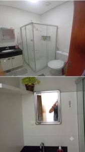 a person taking a picture of a bathroom with a mirror at Edifício Paris 411 in Lagoa Santa