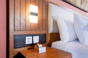 a hotel room with a bed and a table with a alarm clock at ME Villas Pererenan, Canggu in Canggu