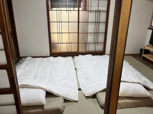 an unmade bed in a room with a window at 御宿空蝉 in Tokyo