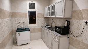 a small kitchen with a sink and a microwave at أرياف سويت in Al Baha +8 photos