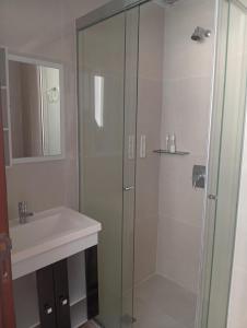 a bathroom with a glass shower and a sink at JG Hotel in Santa Cruz de la Sierra +16 photos