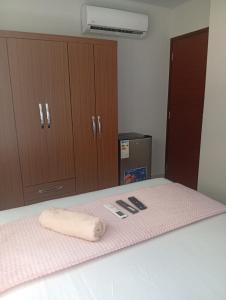 a room with a bed with a towel and cabinets at JG Hotel in Santa Cruz de la Sierra