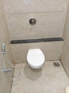 a bathroom with a white toilet in a shower at Dwarka Home Stay in Dwarka