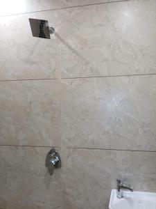 a bathroom with a shower with a sink and a toilet at Dwarka Home Stay in Dwarka