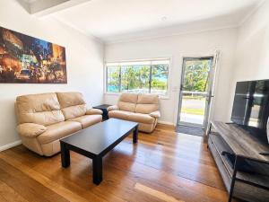 a living room with a couch and a coffee table at Harbour Breeze - apartment in Ulladulla in Ulladulla