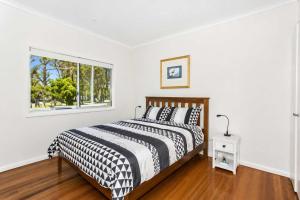 a bedroom with a bed and a window at Harbour Breeze - apartment in Ulladulla in Ulladulla