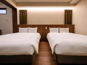 two beds in a hotel room with white sheets at The Hotel Chatan by Sunrest Resort in Chatan +67 photos