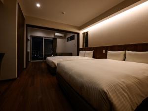 a hotel room with two beds and a window at The Hotel Chatan by Sunrest Resort in Chatan