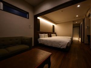 a hotel room with a bed and a couch at The Hotel Chatan by Sunrest Resort in Chatan