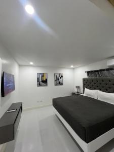 a bedroom with a black bed and a tv at Deluxe two 2 bedroom in Priory