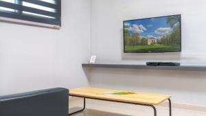 a living room with a table and a tv on a wall at Sokcho Jaja Ocean View Pension in Sokcho