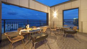 a patio with tables and chairs on a balcony at Sokcho Jaja Ocean View Pension in Sokcho