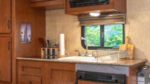 a kitchen with a sink and a window at gyeongju yongcheonsu caravan in Gyeongju +2 photos