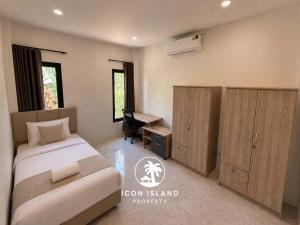a bedroom with a bed and a desk and cabinets at Coco Villa in Hinkong