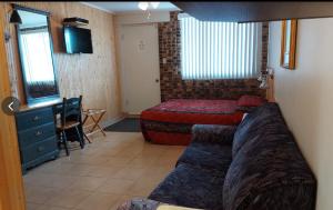 a bedroom with a bed and a desk and a television at Motel Sous Les Charmilles in Cap-Santé