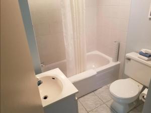a bathroom with a toilet and a sink and a shower at Motel Sous Les Charmilles in Cap-Santé