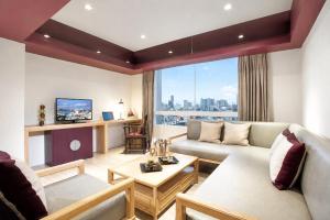 a living room with a couch and a table at The Quarter Hualamphong by UHG in Bangkok