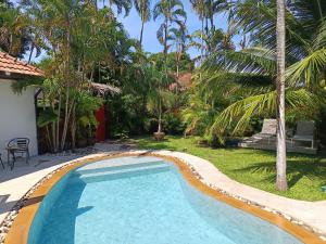a swimming pool in a yard with palm trees at Villa Paradise Island in Rawai Beach