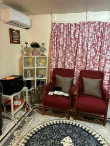 a living room with two chairs and a table at Raiwai Cozy Corner in Suva