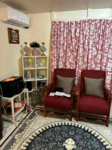 a living room with two chairs and a rug at Raiwai Cozy Corner in Suva
