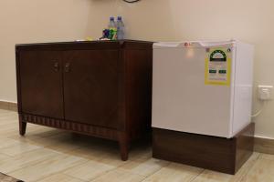 a small refrigerator next to a wooden cabinet at فندق درة الرؤية in Jeddah +21 photos