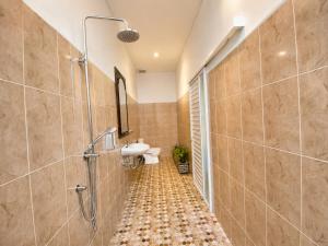 a bathroom with a shower and a sink and a toilet at Pondok DlodPoh in Karangasem