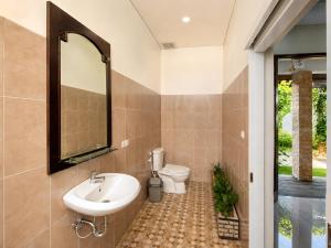 a bathroom with a sink and a toilet at Pondok DlodPoh in Karangasem