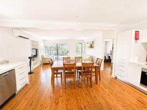 a kitchen and dining room with a table and chairs at Harbour Haven - steps from Ulladulla Harbour in Ulladulla