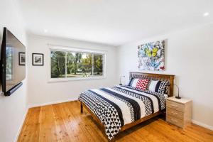 a bedroom with a bed and a window at Harbour Haven - steps from Ulladulla Harbour in Ulladulla +8 photos