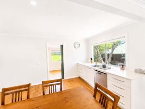 a kitchen with a table and chairs and a window at Harbour Haven - steps from Ulladulla Harbour in Ulladulla