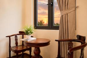 a table and two chairs in front of a window at Red Sun Airport Saigon Hotel in Ho Chi Minh City