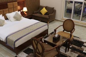 a bedroom with a bed and a chair and a table at فندق درة الرؤية in Jeddah