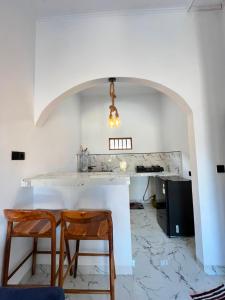 a white kitchen with a table and two chairs at Mahoney Homestay in Kuta Lombok