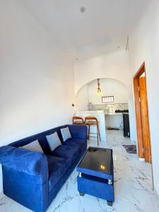 a living room with a blue couch and a table at Mahoney Homestay in Kuta Lombok +23 photos