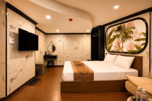 a hotel room with a bed and a tv at Red Sun Airport Saigon Hotel in Ho Chi Minh City