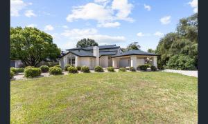 a house with a large lawn in front of it at Sarovar Holidays in Traralgon