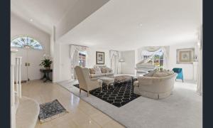 a living room with a couch and a piano at Sarovar Holidays in Traralgon