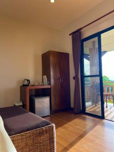 a room with a bed and a sliding glass door at Infinity Heights Resort in Siquijor