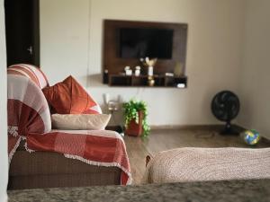 a living room with a couch and a television at Chácara com piscina e lazer em Avaré in Avaré