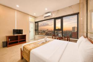 a bedroom with a large bed and a large window at Red Sun Airport Saigon Hotel in Ho Chi Minh City +47 photos