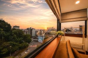 a balcony with a view of a city at sunset at Red Sun Airport Saigon Hotel in Ho Chi Minh City