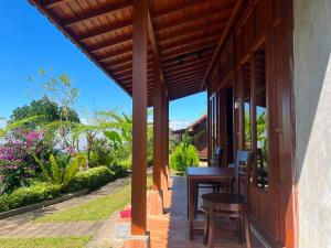 a porch of a house with a table and chairs at Pondok Kayu Pathavi in Baturiti