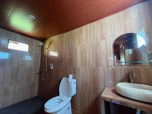 a bathroom with a toilet and a sink at Pondok Kayu Pathavi in Baturiti