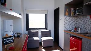 a kitchen with two chairs and a table and a window at Cabañas Julián Elías Roja in Puerto Natales