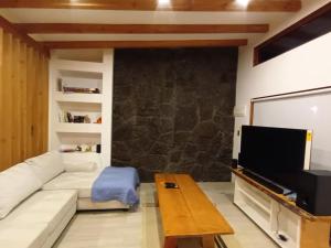 a living room with a couch and a flat screen tv at Cabaña Lafken in Panguipulli