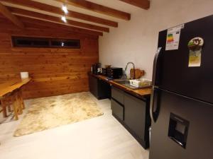 a kitchen with a black refrigerator and a counter at Cabaña Lafken in Panguipulli
