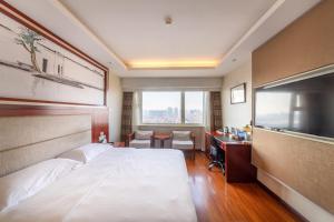 a hotel room with a bed and a desk and a television at Golden Inns Beijing South Railway金泰之家北京南站店 in Beijing