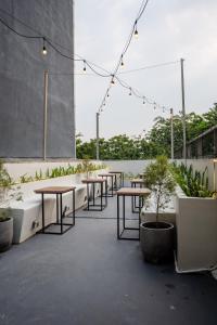 a row of tables and potted plants on a patio at Tuju Arteri Pods in Jakarta