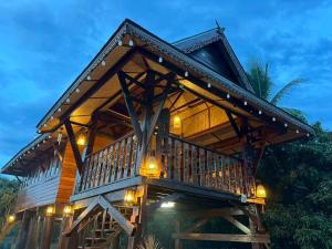 a large wooden house with lights on it at Elephant House and Pool Villas in Ban Sop Ao